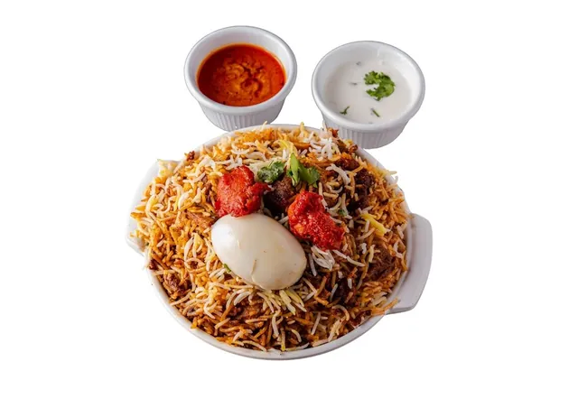 Hyderabadi mutton dum biryani served with egg, mirchi salan and raita